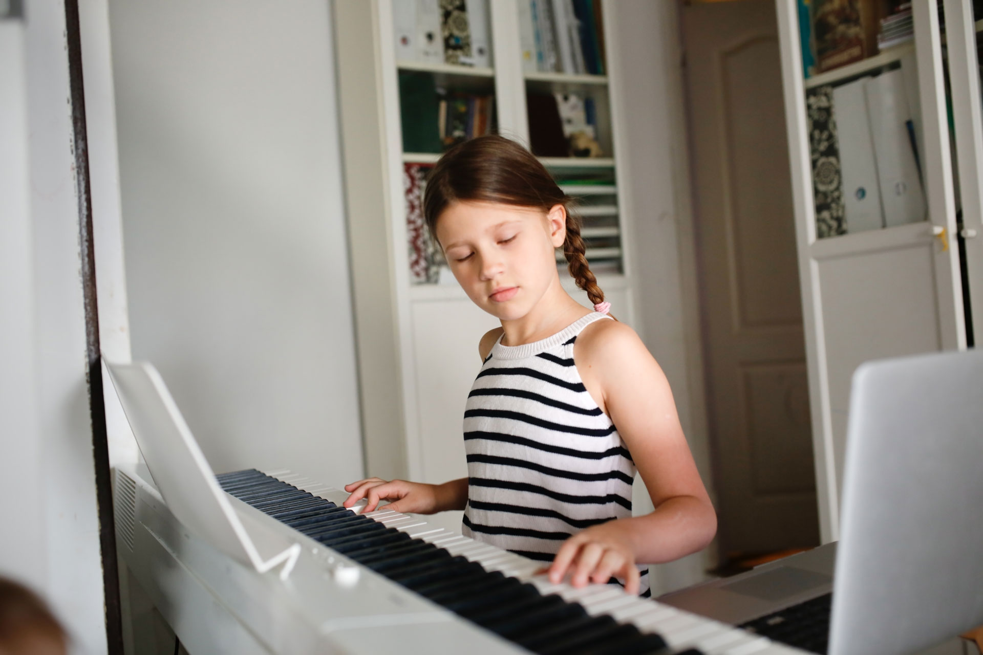 young girl with brown hair playing the piano
