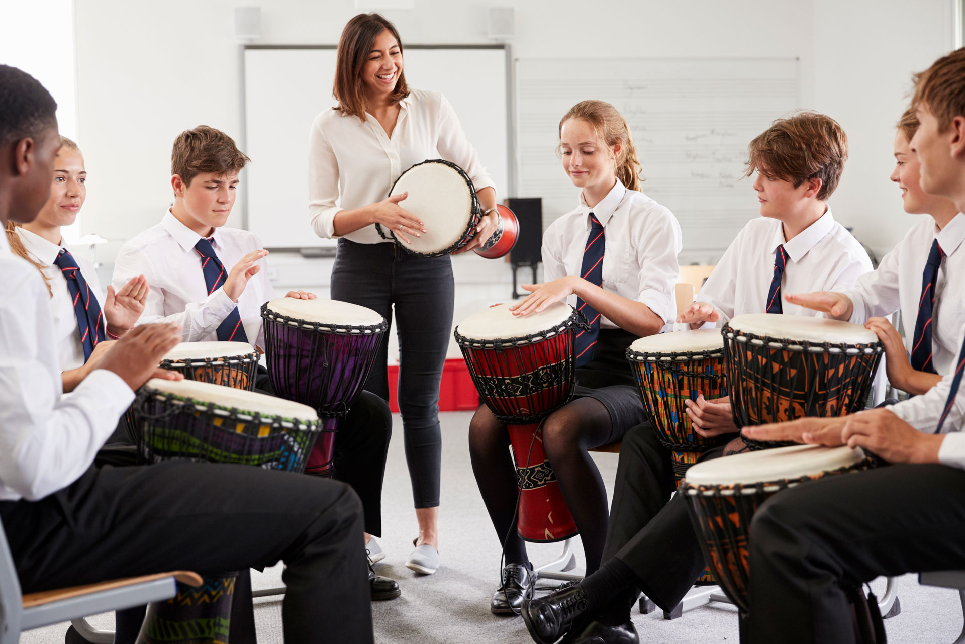 group of students playing drums with teacher