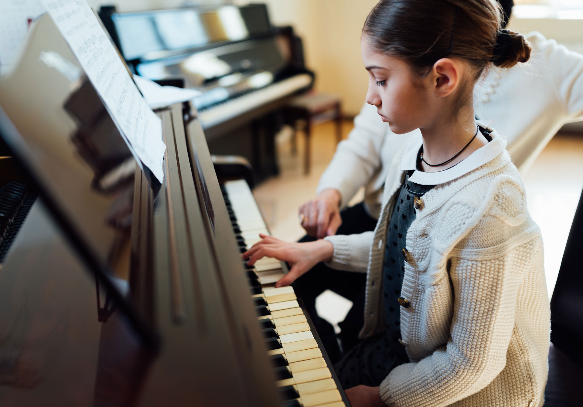 young girl learning how to play the piano